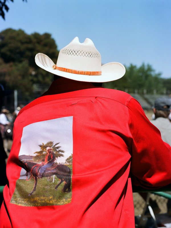 Cowboy Greg Bradley Sr. at The Bill Pickett Invitational Rodeo in Oakland, California. July 2017. He's wearing a shirt with a photo of him on it.